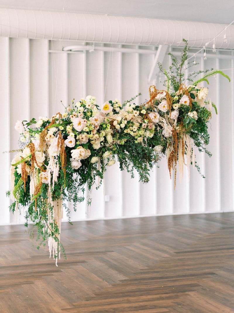 hanging floral installation featuring hanging amaranthus, garden roses, spirea, butterfly ranunculus