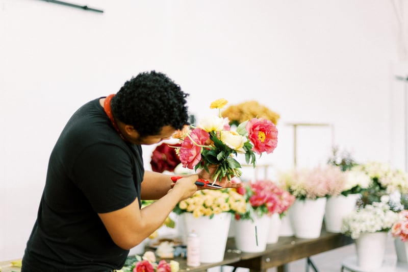 Shean Strong designing a bouquet with garden roses, tree peonies and ranunculus