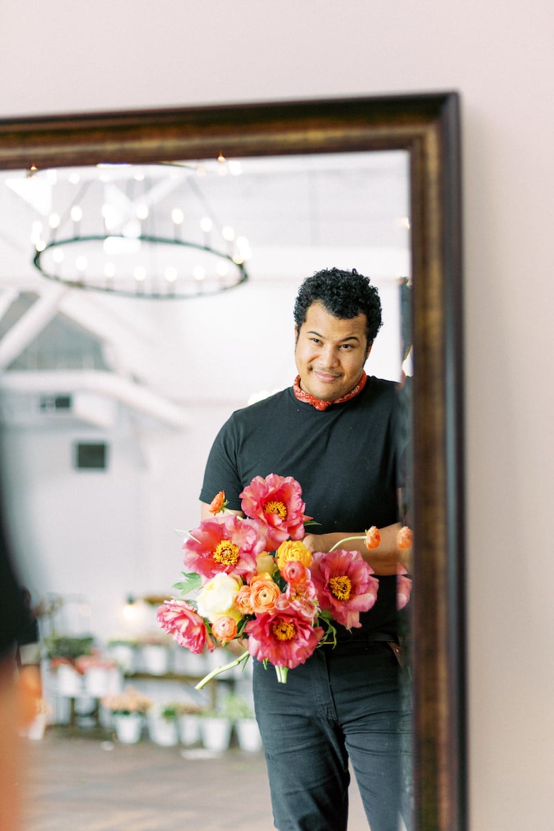 Shean Strong designing a bouquet with garden roses, tree peonies and ranunculus